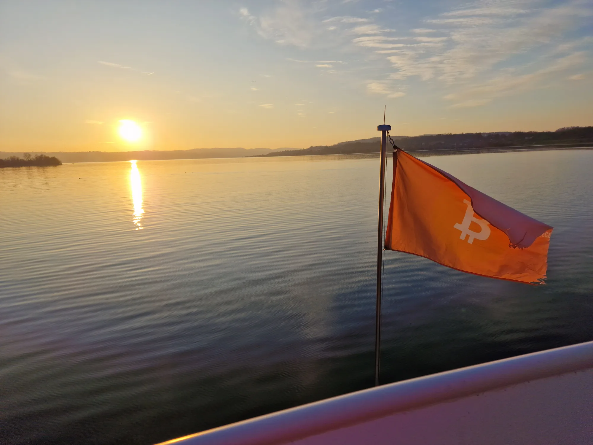 Bitcoin-Fahne bei Sonnenuntergang auf dem Zürichsee